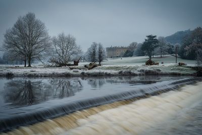 Scenic view of lake against sky during winter