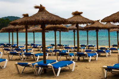 Chairs and parasols on beach against sky