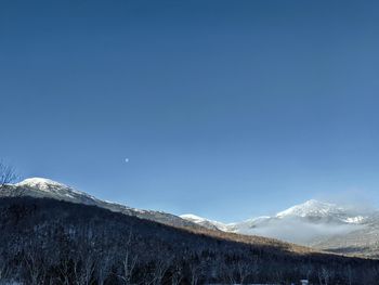 Scenic view of snowcapped mountains against clear blue sky