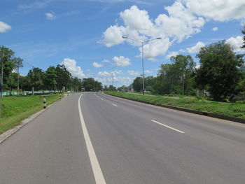 Road by trees against sky