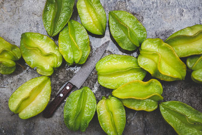 High angle view of green chili peppers on leaves