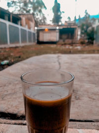Close-up of coffee in glass on table against buildings