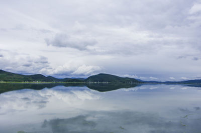 Scenic view of cloudy sky reflecting on calm lake