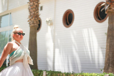 Midsection of woman wearing sunglasses standing outdoors