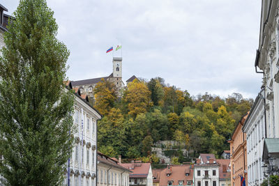 Low angle view of trees and buildings against sky