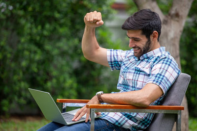 Man using mobile phone while sitting on seat