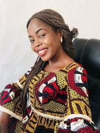 Portrait of a smiling young woman against wall