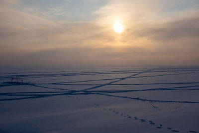 Scenic view of snow covered landscape against sky during sunset