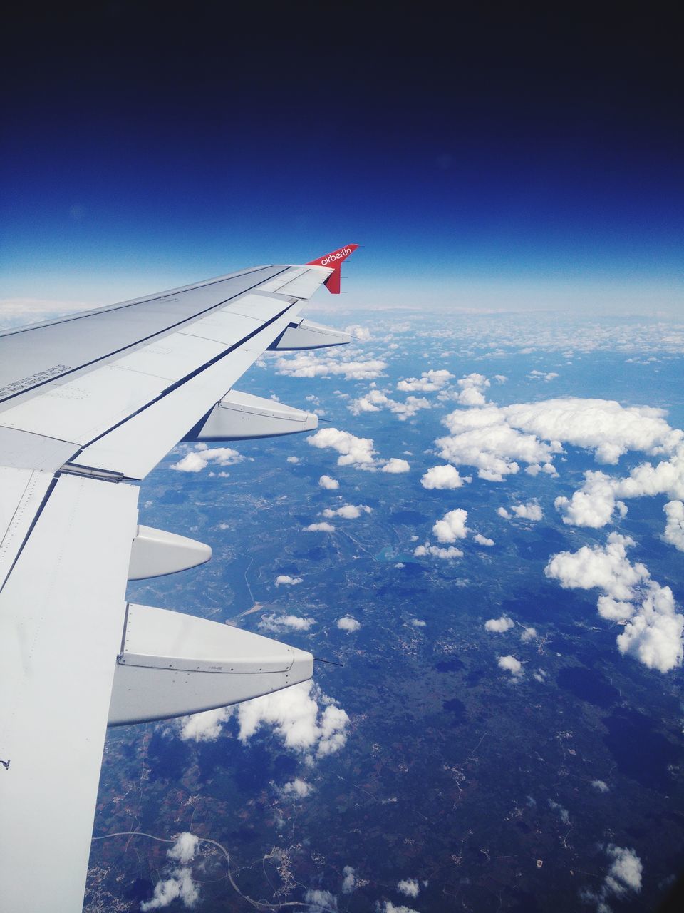 flying, part of, air vehicle, aircraft wing, airplane, mode of transport, cropped, transportation, aerial view, travel, journey, mid-air, landscape, vehicle part, on the move, scenics, blue, cloud, sky, water, tranquility, day, cloudscape, nature, tranquil scene, beauty in nature, cloud - sky, outdoors, airplane wing, sea, solitude, the natural world, meteorology