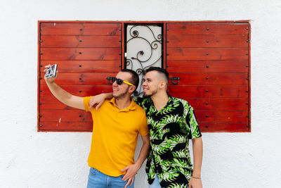 Young couple standing against wall