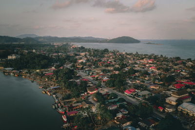 High angle view of city by sea against sky