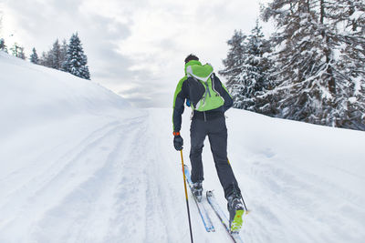 Rear view of people skiing on snowcapped mountain