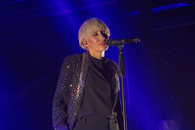 Young woman standing against illuminated lights at night