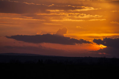 Scenic view of silhouette landscape against orange sky