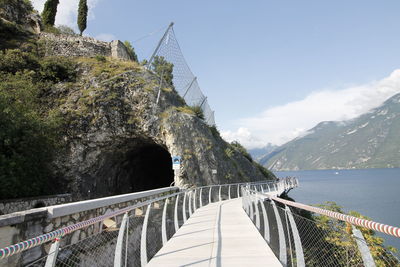 Footbridge over mountain against sky