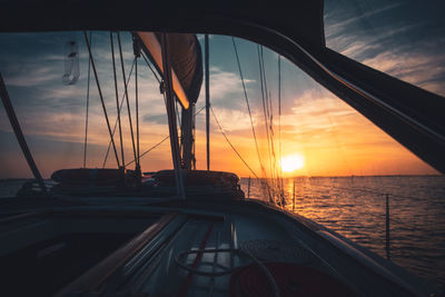 Sailboat sailing on sea against sky during sunset