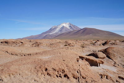 Scenic view of mountains against blue sky