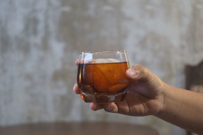 Close-up of hand holding beer glass