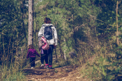Rear view of women walking in forest