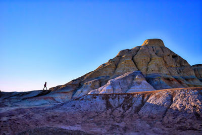 Low angle view of rock formations against clear blue sky