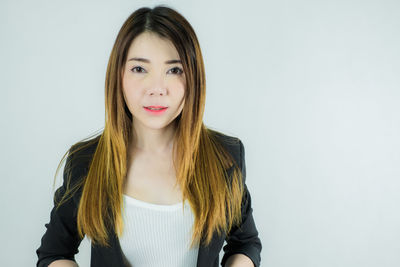 Portrait of beautiful young woman against white background