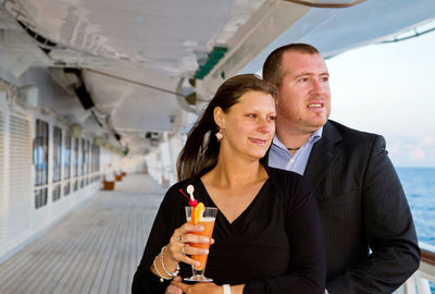 Mature couple looking at sea on ship during sunset