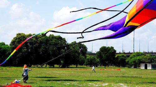 People playing in park against sky