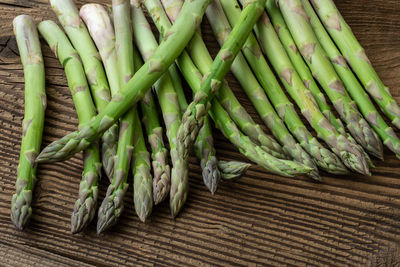 Raw garden asparagus stems. fresh green spring vegetables on wooden background. 