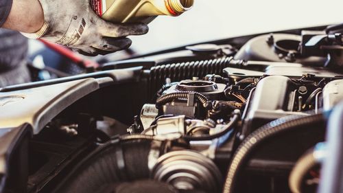 Cropped hand of mechanic repairing car in garage