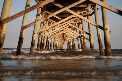 Close-up of pier over sea against sky