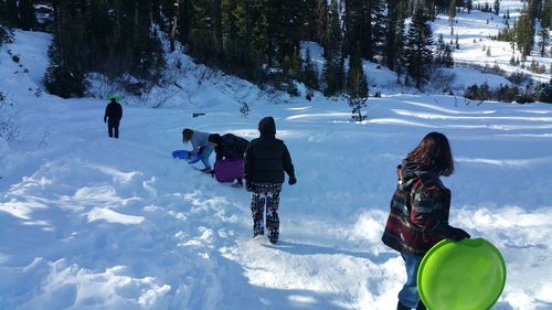 People skiing on snowcapped mountain during winter