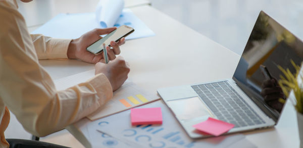 Midsection of man using laptop on table