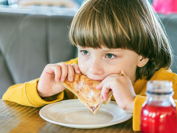 Cute boy eating food in cafe