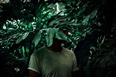 Rear view of man standing by plants