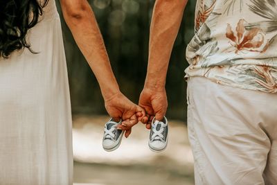 Midsection of couple holding hands