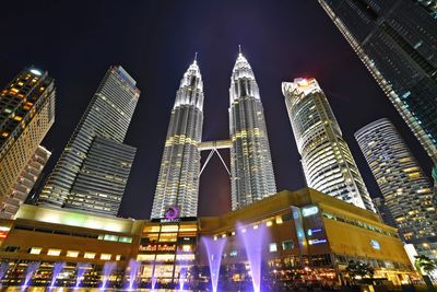 Low angle view of illuminated buildings against sky at night