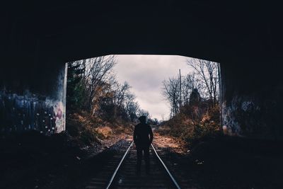 Rear view of silhouette man in tunnel