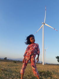 Woman standing on field against clear sky