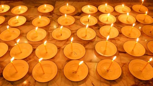 High angle view of tea light candles burning on floor