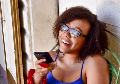 Portrait of smiling woman using smart phone outdoors