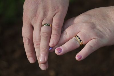 Cropped hands of couple wearing gold rings