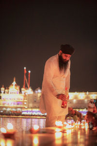 Midsection of man standing on table at night