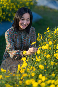 Portrait of a smiling young woman standing on field