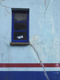 Low angle view of text on blue wall