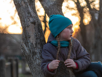 Happy girl with braided hair portrait in spring park on tree sunset outdoor. autumn family leisure