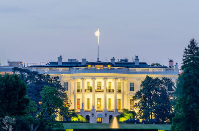 Illuminated building against sky at dusk