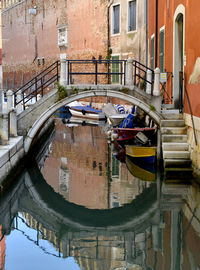 Arch bridge over canal amidst buildings in city