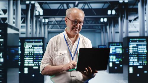 Portrait of man using laptop at airport