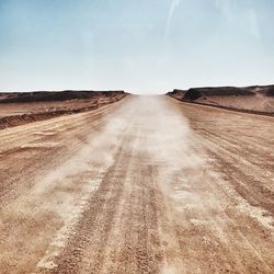 Road amidst field against sky