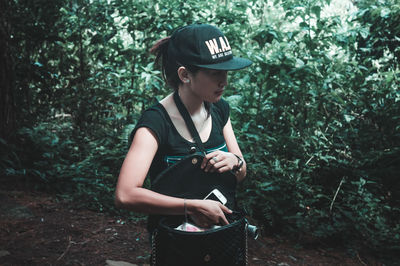 Full length of woman standing in forest